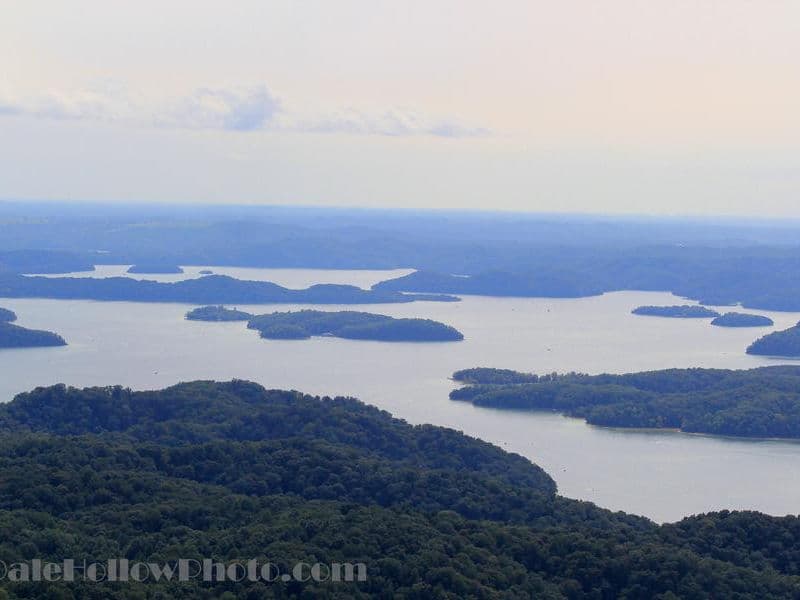 Green hills jutting out from the vast blue waters creates a scenic view Photos