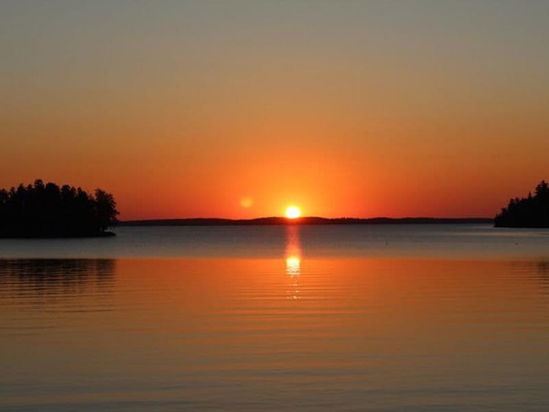 A brilliant sunset over the calm, cool waters of Rainy Lake Photos