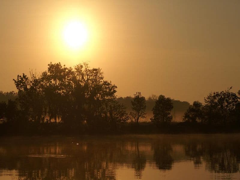 The sun shines over the misty, clear water Photos